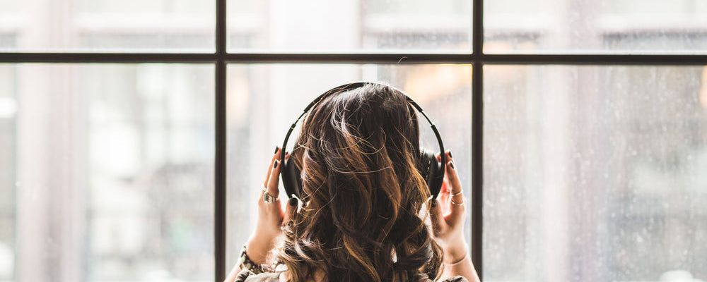 Woman wearing headphones looking out of a window